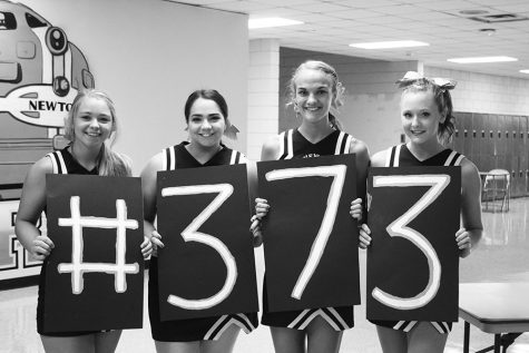Cheerleaders show their support with #373 signs. 