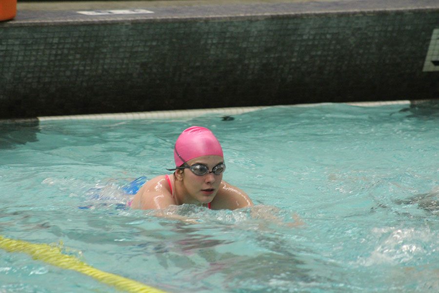 Kicking off of the pool, junior Kit Kingsley makes a headstart down her lane. 