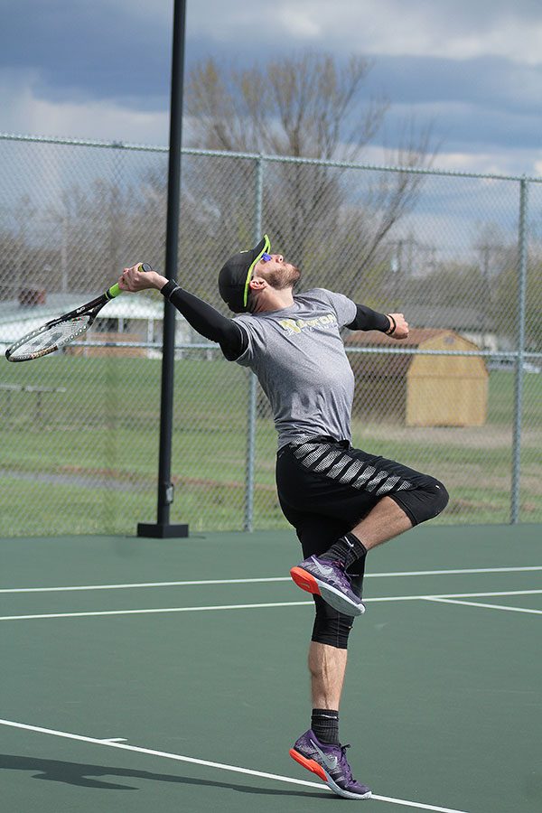 Senior Tyler Neufeld winds his arm back to return the ball to his opponent during a JV meet on April 5. Neufeld had been playing for the Hesston team due to a lack of Hesston players. 