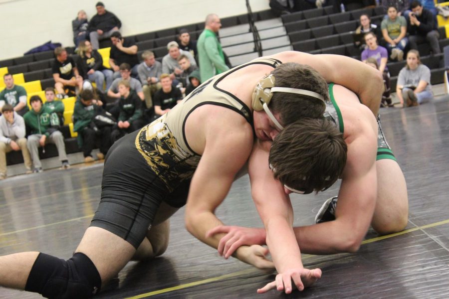 Putting his opponent in a hold, senior Bryan Cusick competes at the home wrestling meet.