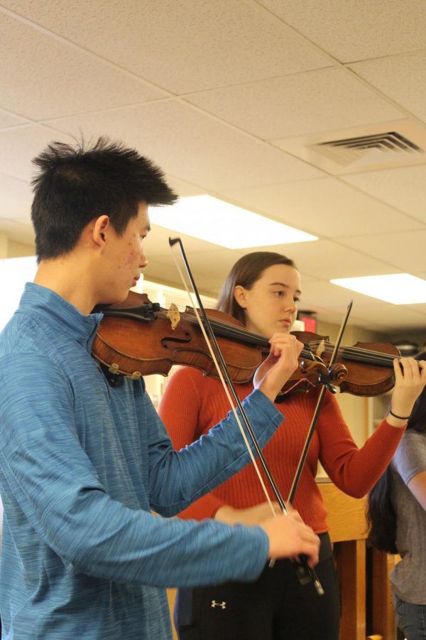 Seniors Jason Wong and Aubrie Nichols play the violin during a chamber orchestra performance at Chisolm Middle School. Wong led the others by playing the first few notes before every piece.