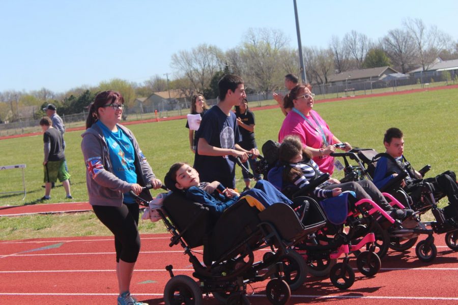 Students and teachers help each other down the track to finish out their event. Many parents and teachers came out to support the students in the track meet and ended the day with a cookout. 
