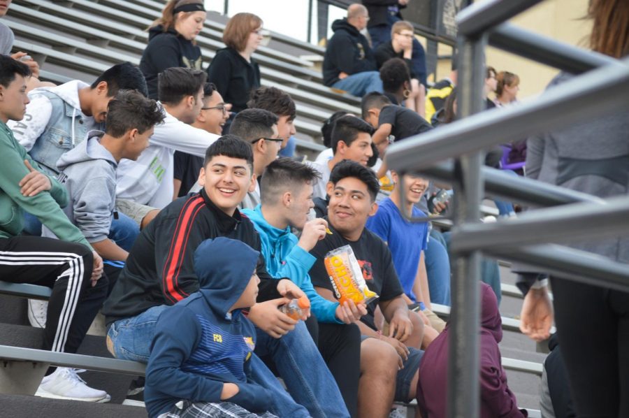 Students watch the game from the stands. The warm weather brought out a number of supporters for the athletes. 