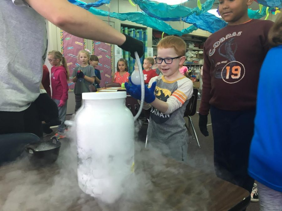 Students interact with experiment demonstrated by Chemistry Club students