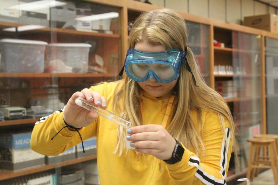 Carefully, junior Reagan Moe pours a chemical into a beaker.
