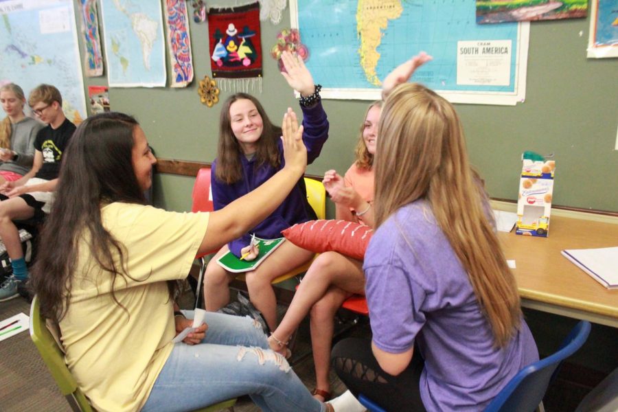 Sophomores McKennah Cusick, Cecilia Erives, McKenna Porter and Jamie Prine all give high fives after getting a question correct in the activity.