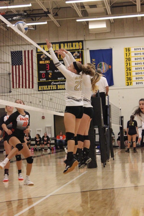Freshman Camryn Entz and sophomore McKennah Cusick jump up to try and get a block. 