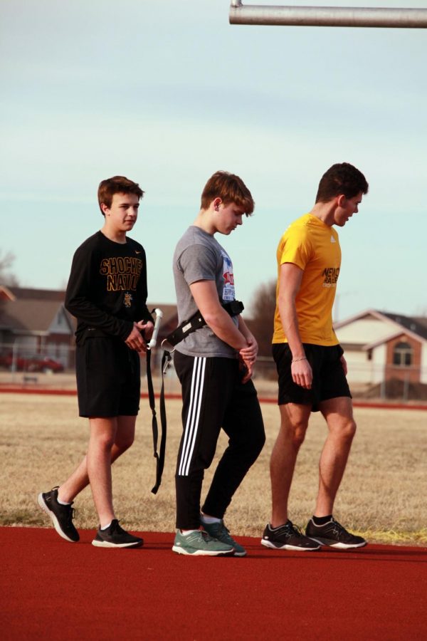  FInishing up their work with resistance bands, sophomores Jonah Remsberg, Ben Crawford and senior Eli Blaufuss walk to meet up with their fellow students.  
