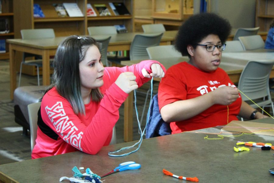 Freshmen Madison Hershberger and Isabel Madrigal choose the string they want to create their bracelets during friendship bracelet club.