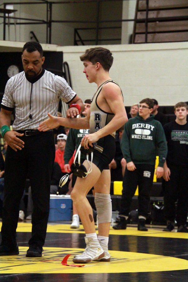 Junior Avery Dutcher shakes his opponents hand after pinning him on the mat. 