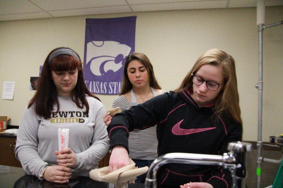 Sophomores Noelle Buentello, Jacey Yager and Tabitha Buffalo work together to build their egg casket. 