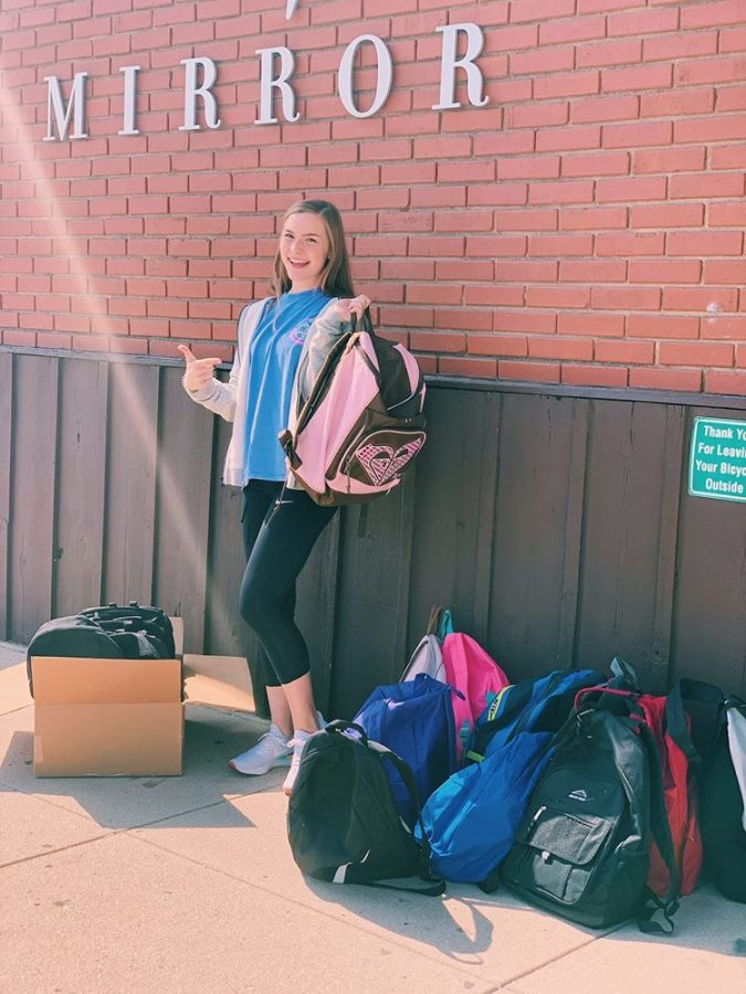 Smiling at the camera, freshman Gracie Hendrickson poses with a fresh start backpack.