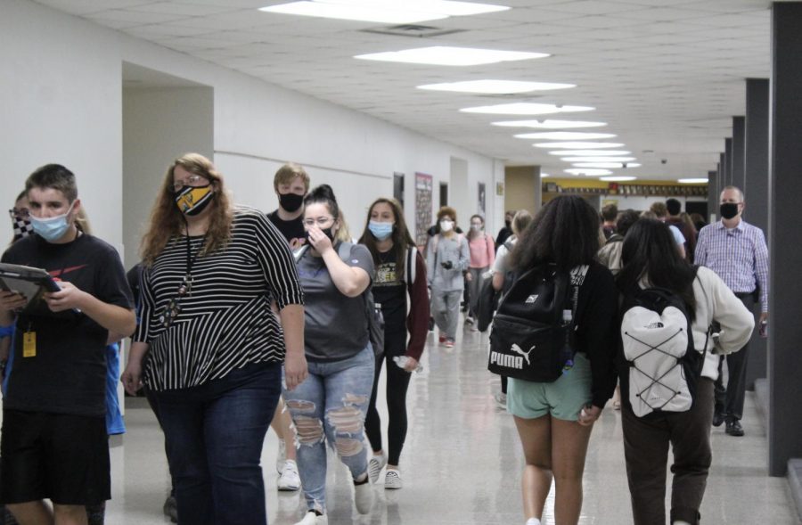 While wearing masks, students and staff walk through the halls before seminar on Sept. 22.