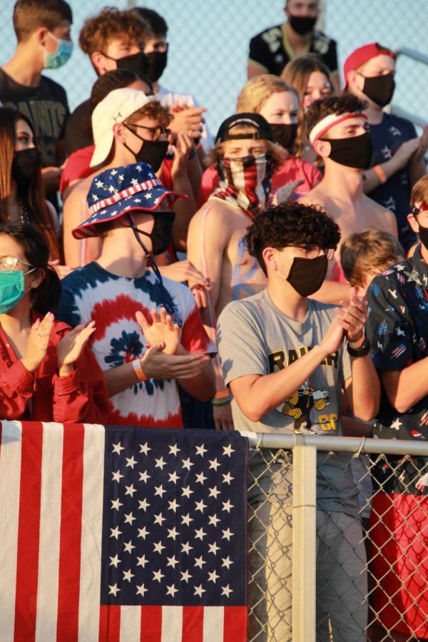 Following the new guidelines put in place, students cheer for the football team while wearing masks to stop the spread of COVID-19.