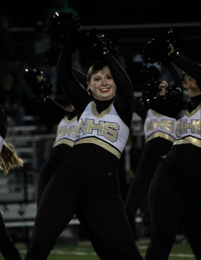 Senior+Evie+Bartley+shakes+her+poms+over+her+head+while+preforming+at+the+home+varsity+football+game+on+Sept.+11.