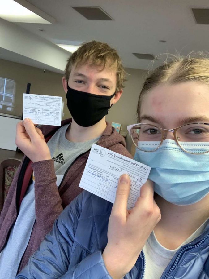 Juniors Ben Friesen Guhr (left) and Daisy Buller (right) pose with their COVID-19 Vaccination Record Card after receiving their first dosage of the vaccine.