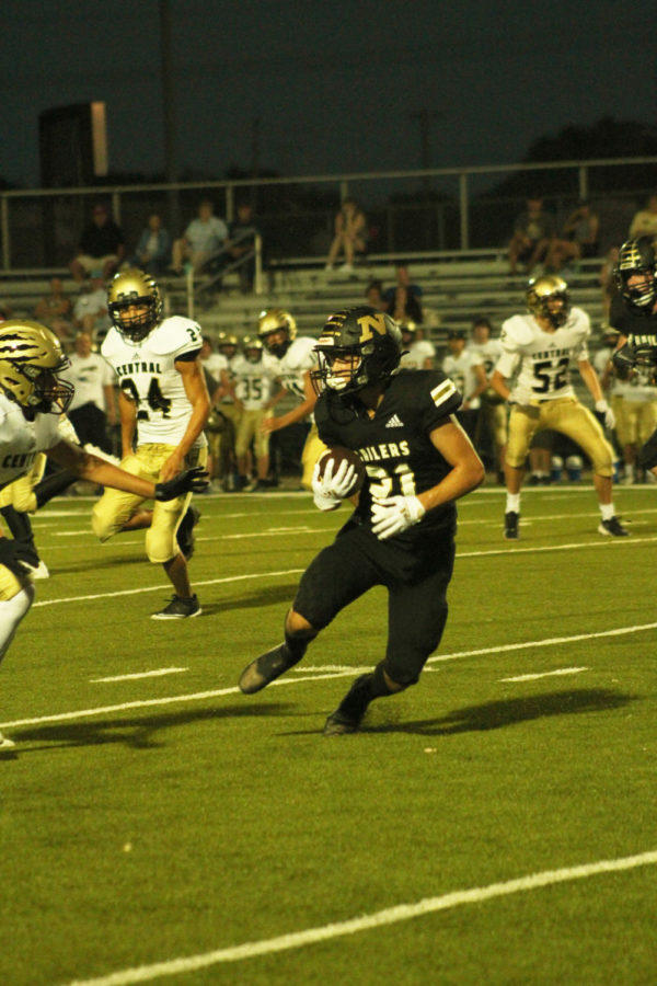 Trying to run the ball down the field, junior Dylan Mcbee avoids his opponent. 