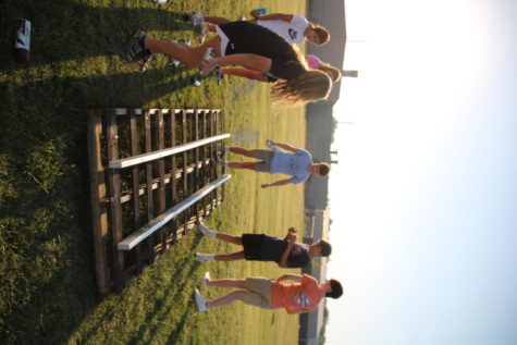 Freshman work together to make train tracks for their float. 