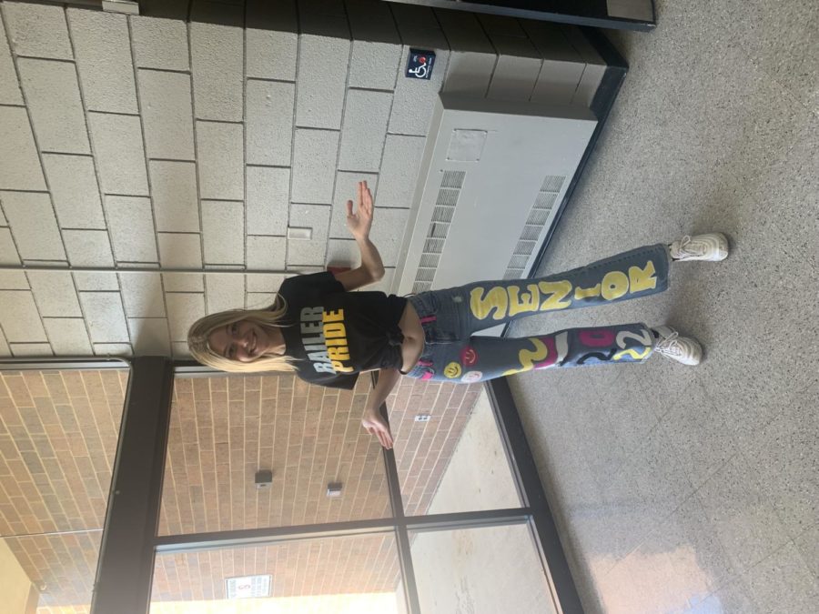 Senior Hallie Watkins poses for a picture with hand painted jeans on railer  pride day. 