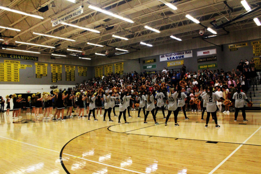 The cheer and dance team cheer with the students to get the pep assembly going.