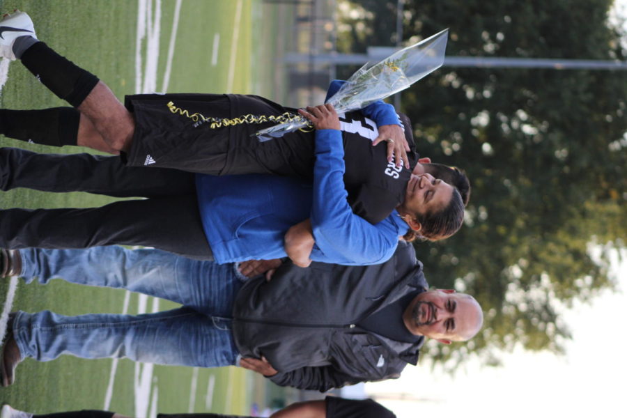 Hugging his mother on the field, Senior Darwin Maldonado is recognized at Senior Night.