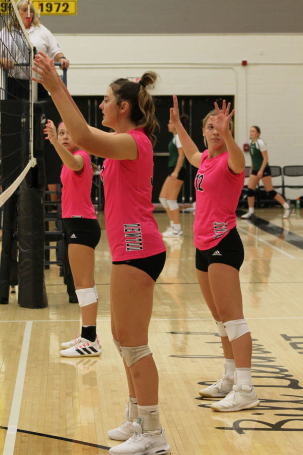Preparing to block the ball, junior Tegan Livesay lifts her arms and watches the upcoming serve. 
