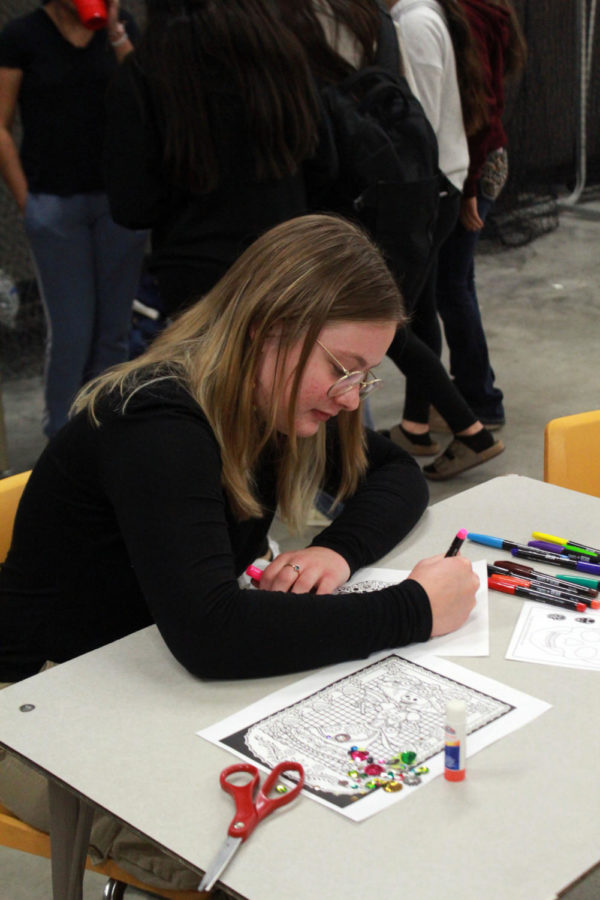 Sophomore Ava Siebert colors her coloring page with markers  on Oct.29 during Spanish club.