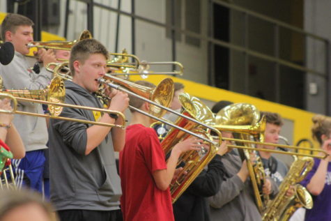 The boys in the horn section of the band stand up to play their instruments 