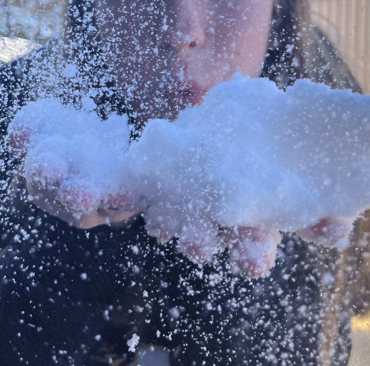 A NHS student blows snow during the winter storm